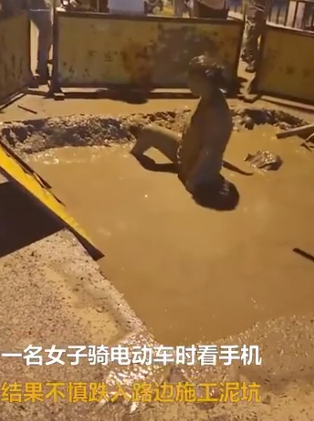 女子骑车看手机跌泥坑执着捞手机 女子骑车看手机跌泥坑执着捞手机